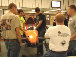 Students inspect the vehicle that the Glencoe-Silver Lake YES! team used to compete in the Supermileage Challenge last May.