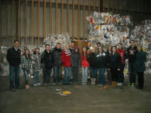 YES! Teams from EVW, Litchfield and Rocori stand in front of baled cardboard ready for shipping